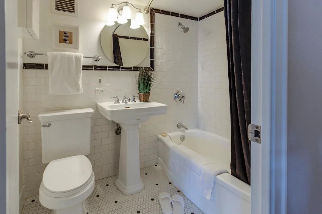 Minimalist room with a person cleaning a chair using a sponge and cleaning product.